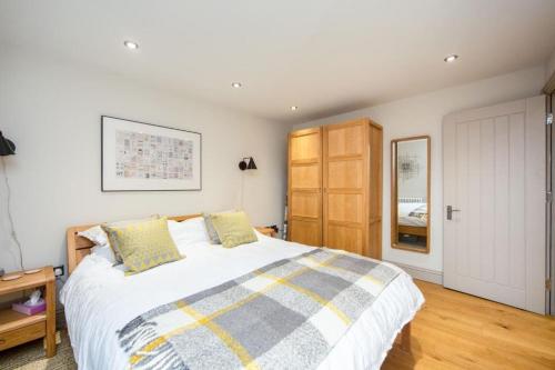 a bedroom with a large bed and a wooden cabinet at Stylish two bed flat, city centre, free parking in Wells