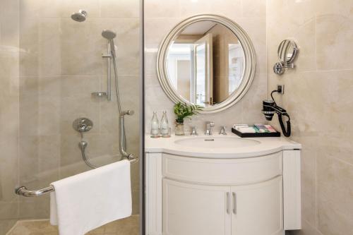 a bathroom with a sink and a shower with a mirror at Meliá Vinpearl Danang Riverfront in Danang