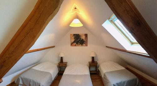 two beds in the attic of a house at Camping La Garenne De Moncourt in Rue