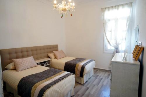 a hotel room with two beds and a chandelier at Tetouan Luxury Apartment in Tetouan