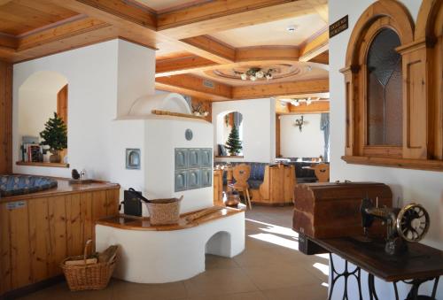 a large kitchen with wooden ceilings and a wooden table at Hotel Villa Aurora in San Martino di Castrozza