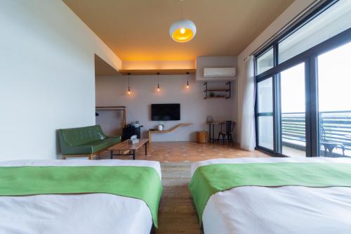 a hotel room with two beds and a television at 時光輕旅 Time INN in Hengchun