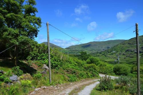a dirt road with mountains in the background at Secluded cottage nestled in the Beara Peninsula in Killarney
