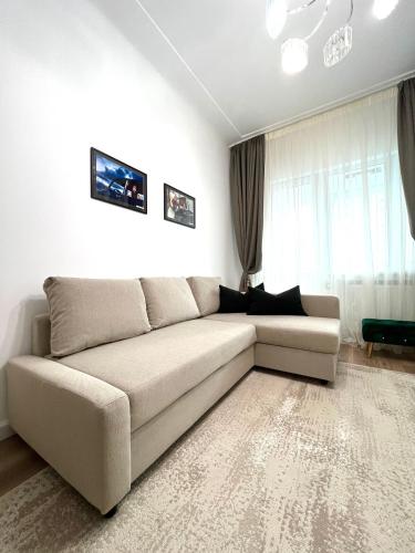 a living room with a couch in front of a window at Sky View - Luxury Apartament - Sanador Victoriei in Bucharest