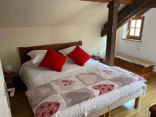 una camera da letto con un letto con cuscini rossi di Gîte 4* Duplex centre historique Riquewihr a Riquewihr