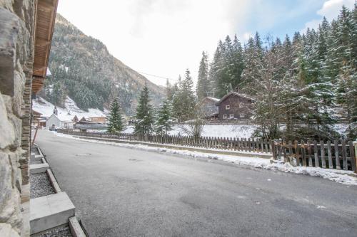 a road with a fence and snow on the ground at W-Spirit Apartments in Jerzens