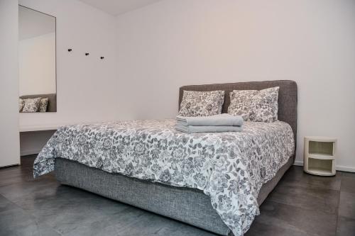 een bed met een zwart-witte deken en kussens bij Front Lake Apartment Meli With View Feel Ticino Feel Home in Melide