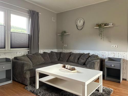 a living room with a couch and a table at Ferienhaus "Zauberwald" mit Pelletofen & Sauna in Meschede