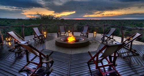 un grupo de sillas sentadas alrededor de una hoguera en Makumu Private Game Lodge, en Reserva Natural de Klaserie