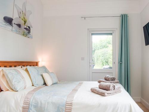 een slaapkamer met een groot bed en handdoeken bij The Lodge At Forbury Cottage in Kimbolton
