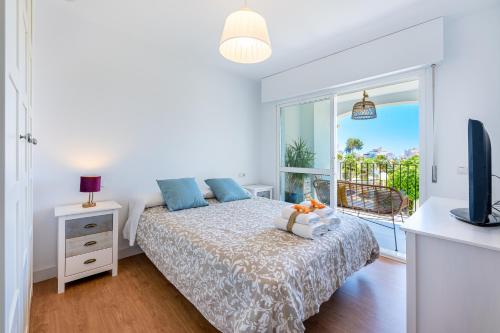 a bedroom with a bed and a tv and a balcony at 797 Holiday Rentals - Moderno piso para 4 cerca de la playa in Benalmádena