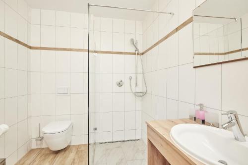 a bathroom with a shower and a toilet and a sink at Landhotel Berger in Ainring