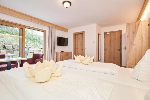 a bedroom with two white beds and a table at Landhotel Berger in Ainring