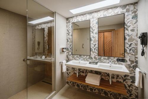 a bathroom with a sink and two mirrors at Riu Latino - Adults Only - All Inclusive in Costa Mujeres