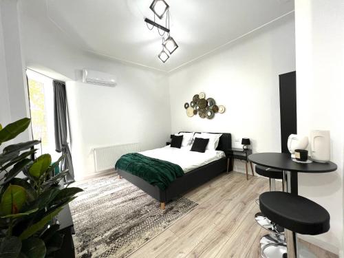 1 dormitorio con 1 cama, mesa y sillas en Green Spot - Premium Studio - Sanador Victoriei en Bucarest