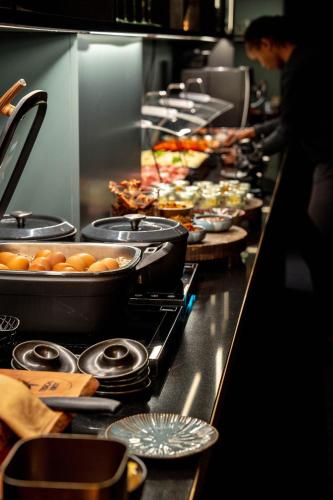 a buffet line of food in a restaurant kitchen at Aiola Living Graz in Graz