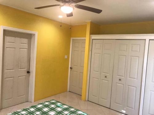 a room with two white doors and a ceiling fan at palmvillo master suit 