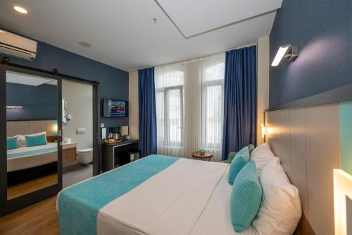 a bedroom with a large bed with blue walls at Juno Hotel Taksim in Istanbul