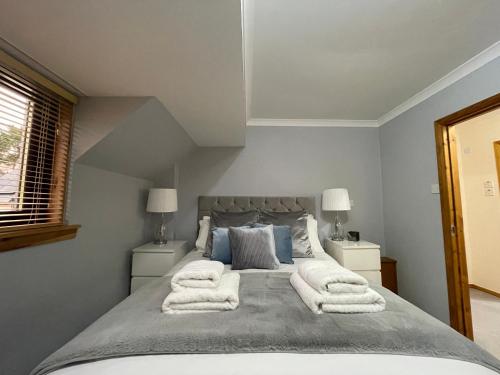 a bedroom with a large bed with towels on it at Scandinavian Village Ltd in Aviemore