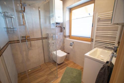 uma casa de banho com um chuveiro, um WC e um lavatório. em Antosiowy domek em Wisla