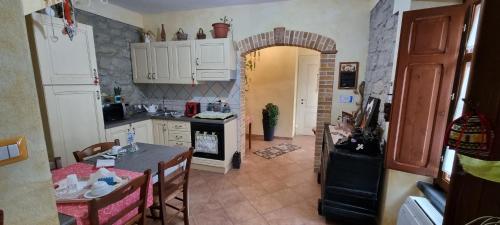 a kitchen with white cabinets and a table with chairs at B&B Martina in Senorbì