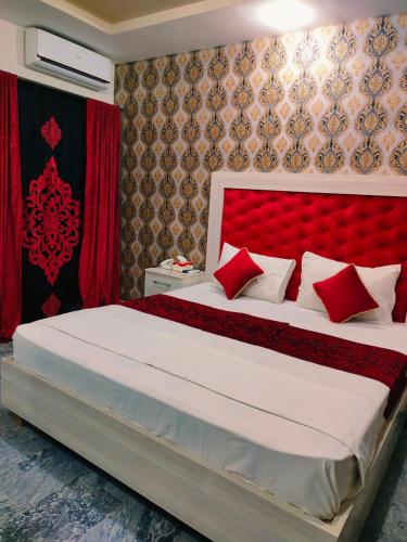 ラホールにあるHotel Park Viewのベッドルーム1室(赤いヘッドボード付きの大型ベッド1台付)