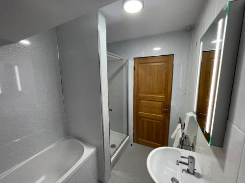 a bathroom with a sink and a tub and a toilet at Scandinavian Village Ltd in Aviemore