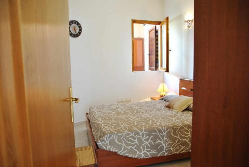 een slaapkamer met een bed, een lamp en een deur bij La Sirenetta tra mare e collina in Sperlonga