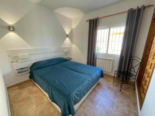 a bedroom with a bed with a blue blanket at Apartamento Panorama X0025 in Benitachell