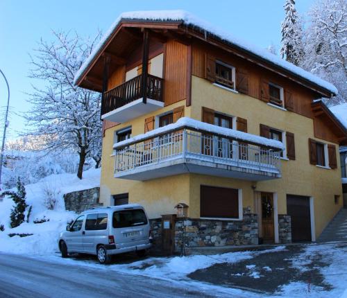 a house with a balcony and a van parked in front of it at Y'hello studio in Mâcot La Plagne