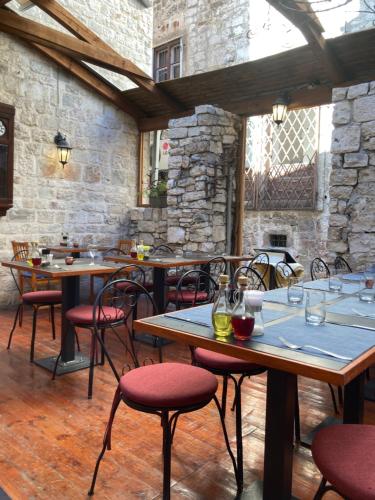 a restaurant with wooden tables and red chairs at Dragazzo room in Trogir