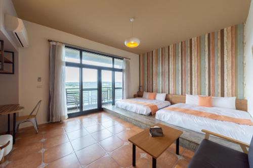恆春的住宿－時光輕旅 Time INN，酒店客房设有两张床和大窗户。