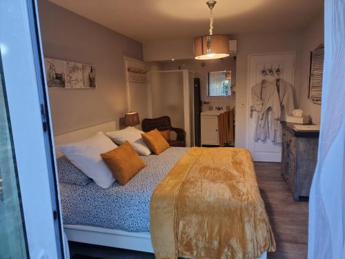 a bedroom with a bed with pillows on it at Le Clos des Romarins in Saint-Palais-sur-Mer