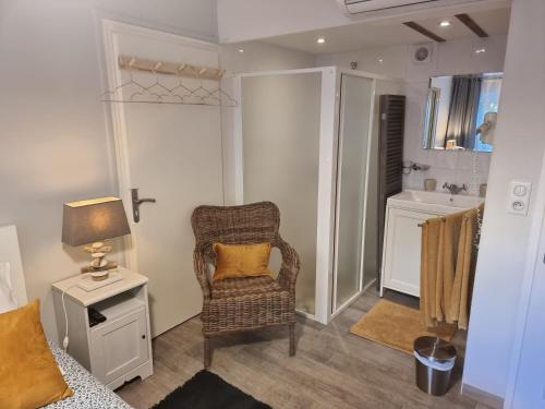 Habitación con silla, lámpara y lavabo. en Le Clos des Romarins, en Saint-Palais-sur-Mer