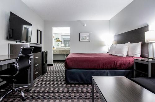 Habitación de hotel con cama y escritorio en Brick Lodge Atlanta/Norcross, en Norcross