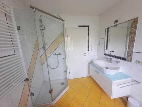 a bathroom with a glass shower and a sink at Ferienwohnung Rosengarten in Öhringen
