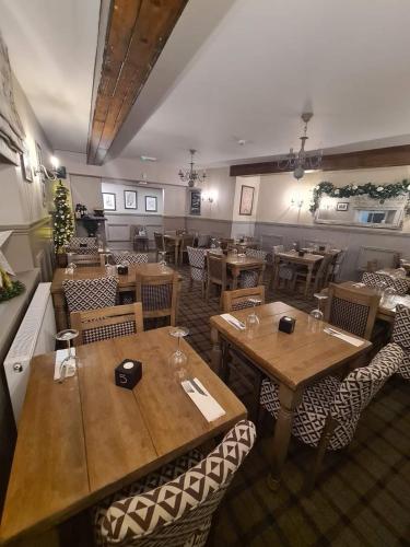 a restaurant with wooden tables and chairs in a room at Royal Oak Braithwaite in Keswick