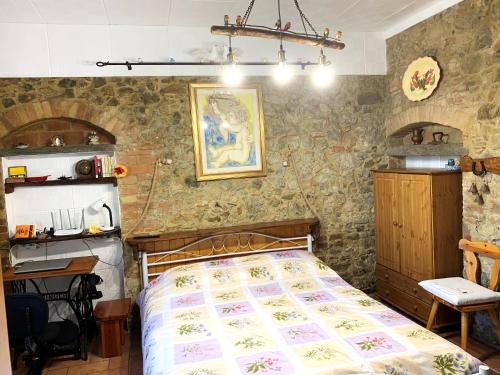 a bedroom with a bed in a room with stone walls at Casa Fabbrichina in Gambassi Terme