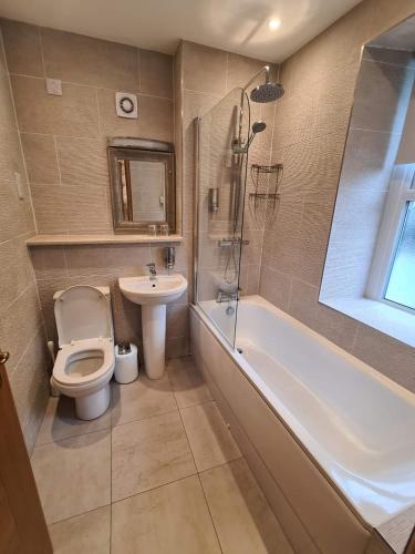 a bathroom with a toilet and a tub and a sink at Royal Oak Braithwaite in Keswick