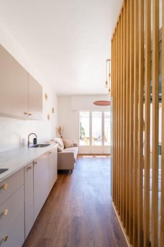 une cuisine avec des armoires blanches et un plancher en bois dans l'établissement Studio tout confort à deux pas de l'océan - Wifi, à Biscarrosse