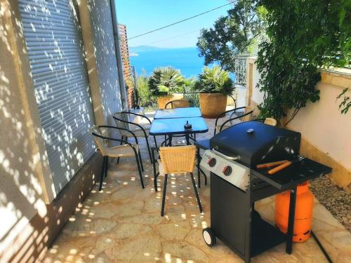 a grill and tables and chairs on a patio at Apartments Oktopus in Sutomore