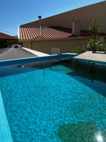 uma grande piscina azul em frente a uma casa em Casa do Eirô em Resende