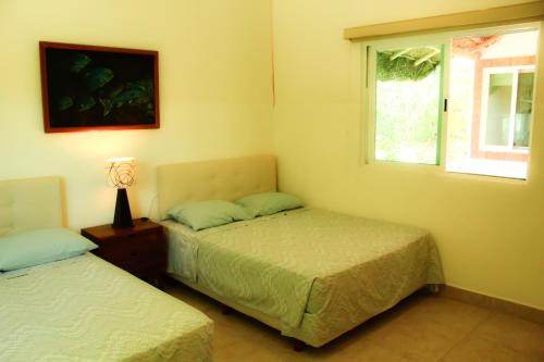 a bedroom with two beds and a window at Rodas villas contiguas para la vacación perfecta in San Bruno