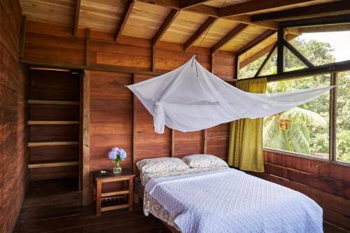 a bedroom with a bed with a mosquito net at Casa Balae in Nuquí