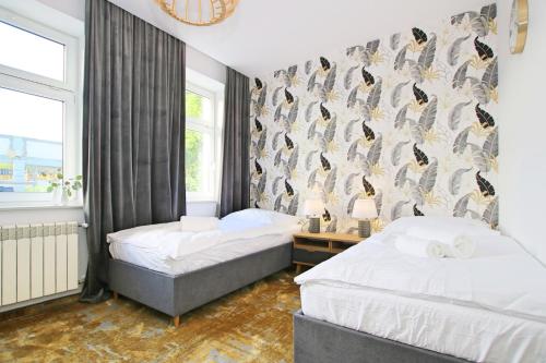 a bedroom with two beds and a wall with penguins at Willa Portus in Słupsk