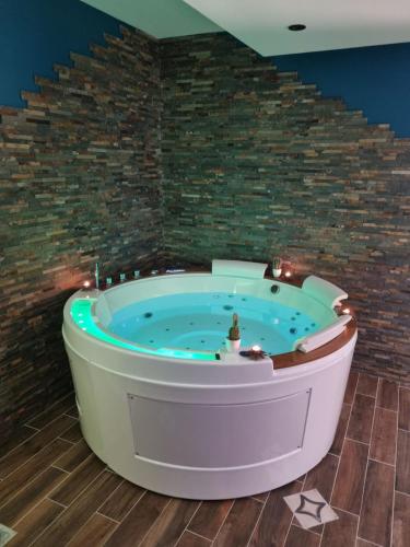 Cette chambre dispose d'un bain à remous et d'un mur en briques. dans l'établissement Gite avec Spa 