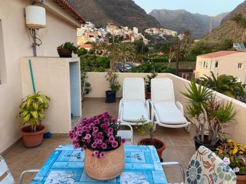 a balcony with chairs and a table with flowers on it at Casa Isidoro in Valle Gran Rey