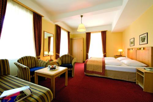 pokój hotelowy z łóżkiem i kanapą w obiekcie Hotel Gisela w mieście Bad Gastein