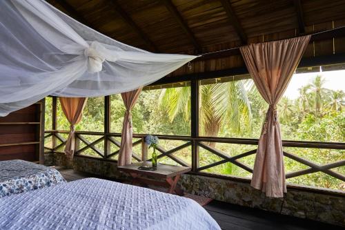 a bedroom with a bed and a large window at Casa Balae in Nuquí