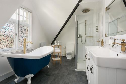 uma casa de banho com uma banheira azul e um lavatório. em The Royal Adelaide Hotel em Windsor